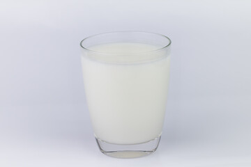 The cow's milk close-up is refreshing white In a clear glass container The image has blank space beside the object and has a white background. The image is partially clear.