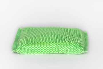 New sponge for washing dishes The sponge is green and has a mesh covering the sponge and white background.