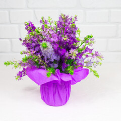 Beautiful bouquet of lilac purple flowers in a vase on a white background. Mother's day. Greeting card.