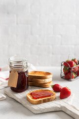 Fresh strawberry jam or confiture with crunchy toast for breakfast. Side view. Social media content. Cookbook recipe. Copy space for text. Natural organic food. Seasonal summer food