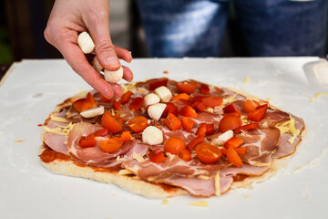 Making of homemade Italian pizza in fireplace brick oven.