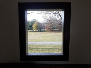 open window looking out to trail, grass,trees, and road