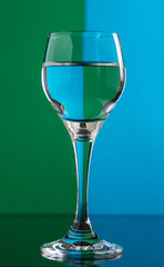 Glass of drink on green and blue background