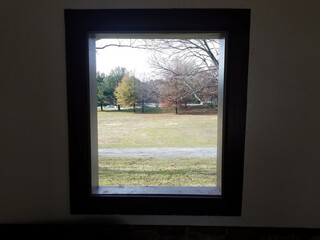 open window looking out to trail, grass,trees, and road