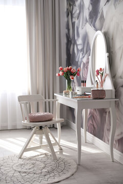 Stylish room interior with elegant dressing table and floral wallpaper