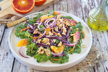 Vegetarian food. Vegetable salad with kale, blood oranges, red cabbage, red onions, walnuts and olive oi