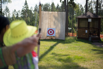 Young woman aiming with a bow