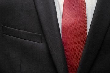 Closeup of black business suit with white shirt and red tie. Businessman in a black suit with a red tie. Business concept.