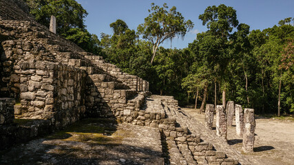 Ancient Maya ruins of Calakmul in the thick jungle and tree landscapes on a sunny day in the Yucatán Peninsula of Mexico.