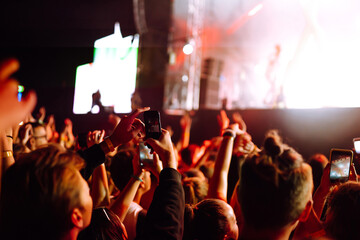 Hand with a smartphone records live music festival, Taking photo of concert stage. Youth, party,...