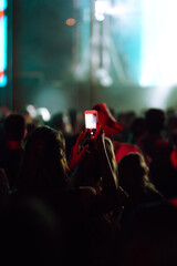 Hand with a smartphone records live music festival, Taking photo of concert stage. Youth, party,...