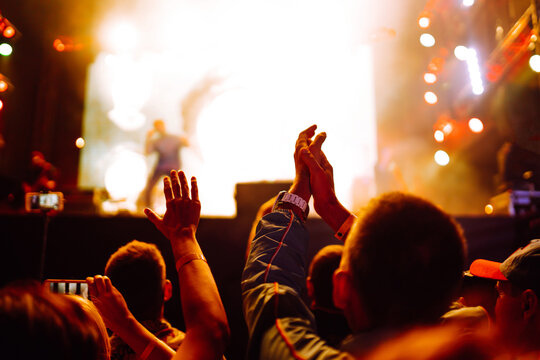 Crowd raises hands and applauds at a music festival. Youth, party, live concert. 