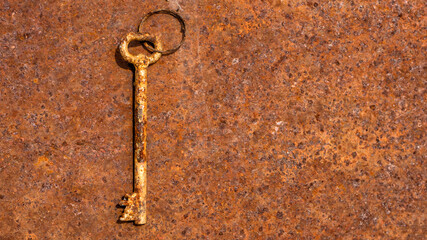 One old rusty keys on ring shot on steel textured background. Copy space.