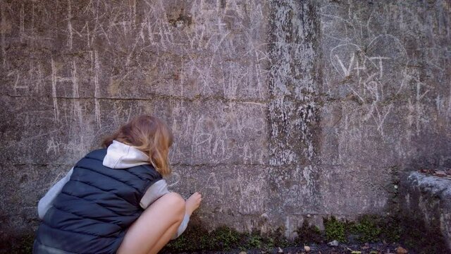 Etching letters into a stone wall
