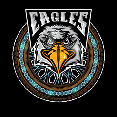 Eagle's head in center of motorcycle wheel, color label on black background