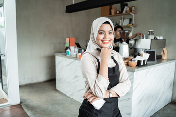 Fototapeta na wymiar veiled waitress girl with a smile pose with a pub cafe background