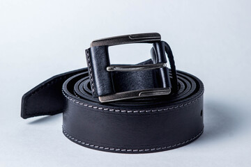 Black leather belt on a black background. Men's belt.