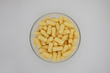 corn sticks in a transparent plate on a white background
