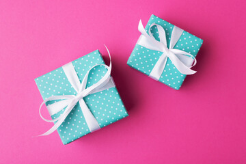 Fototapeta premium Big and small alike gift boxes on pink background