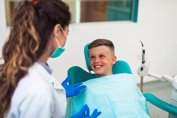 Cute little boy sitting on dental chair and having dental treatment.