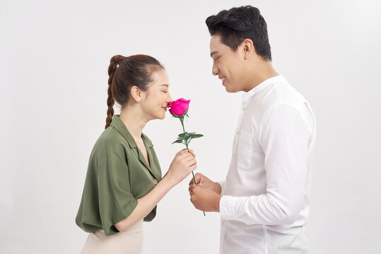 Man offering a rose to his girlfriend over white