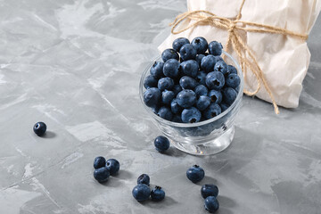 Blueberry gray background. Close-up, ripe blueberry berries on a gray background ecological packaging. Delivery of products, copies of space, photos for the catalog of stores.