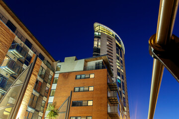Modern high rise apartment building at night - low angle view. 