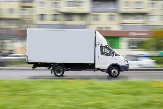 Side view of a cargo delivery truck blurred with an copy space on a blurred background in traffic