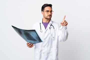 Young doctor man holding a radiography isolated on white background touching on transparent screen