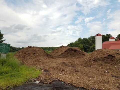 Large Pile Of Mulch And Silo