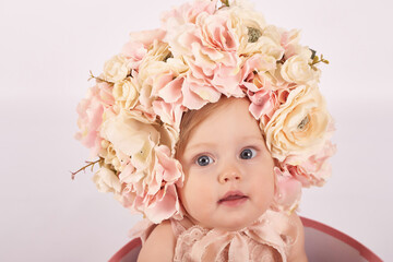 Sweet funny baby in hat with flowers. Easter greeting card, copyspace for your text. Poster for Easter holiday. Congratulations on Mother's Day. Cute baby girl. Children Protection Day