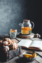 A book with citrus tea is waiting in a vintage kitchen. Rest, hobbies, education, read.