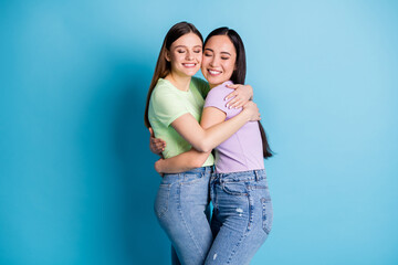 Profile photo of cheerful lesbians couple hugging good mood young students best friends fellows buddies eyes closed wear casual green purple t-shirts jeans isolated blue color background