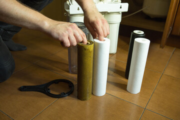 Changing filters in your home water purification system. The master prepared to replace the first...