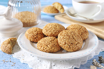 Sesame cookies and cup of tea, sweet breakfast on blue background