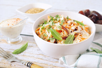 Coleslaw salad with carrots, dates and sauce for diet food, mint leaves dressing