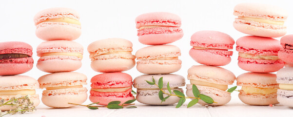banner Colorful French or Italian macarons stack on white wood table with copy space for background. Dessert for served with afternoon tea or coffee break