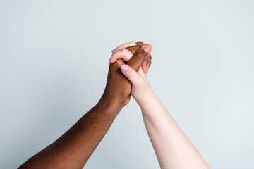 Closeup photo of two hands arms different race multinational couple best friends anti racism issue help support together love save world romantic date isolated grey color background