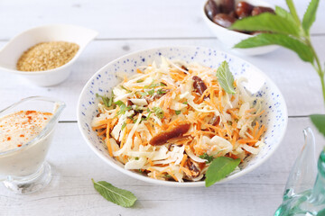 Coleslaw salad with carrots, dates and sauce for diet food, mint leaves dressing