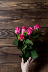 female hand holds a bouquet of red roses