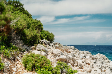 Fototapeta na wymiar Seascape, Mediterranean coast. White rocks stones and blue water, sky with clouds
