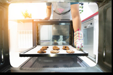 View from inside the oven of a young man baking cookies