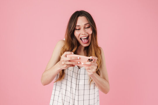 Image of excited caucasian woman playing video game on cellphone