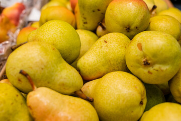juicy ripe pears lie on top of each other with a bunch. The light is pleasantly reflected from them. lenty of delicious juicy fruit. High quality photo