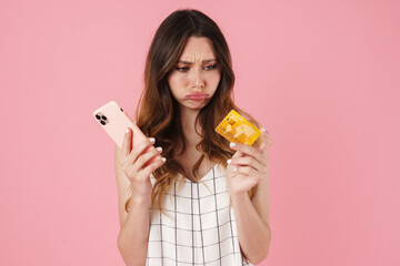 Image of displeased nice woman holding cellphone and credit card
