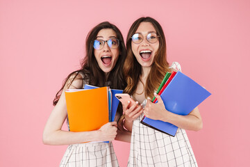 Image of student women holding exercise books and using cellphone
