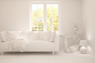 Fototapeta premium White stylish minimalist room with sofa and autumn landscape in window. Scandinavian interior design. 3D illustration