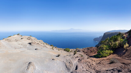 Fototapeta na wymiar Graue Erosionslandschaft an der Nordküste von La Gomera oberhalb Agulo mit Blick zur Nachbarinsel Teneriffa