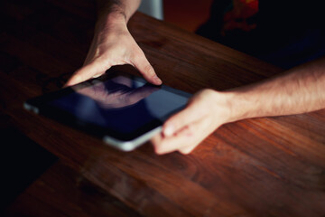 Close up shot of a man's hands using a digital iPad tablet at office 