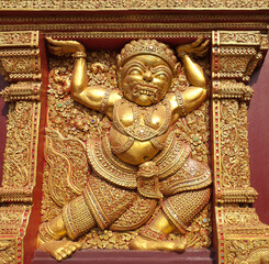 Fototapeta na wymiar Golden bas relief in Thai style with demon guardian at famous Wat Sri Suphan Temple in Chiang Mai, Northern Thailand